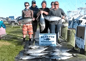 Group standing behind their catch at docks after an affordable family friendly fishing charter.