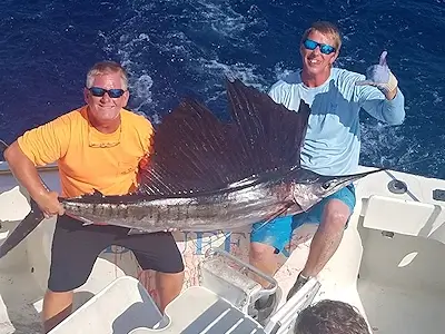 Angler and mate holding up a nice sailfish before releasing it.